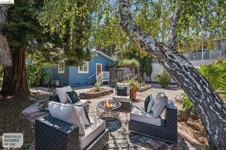 Expansive backyard hardscaping with a brick patio, stone pathways, and a fire pit