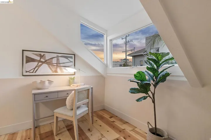 Angled white walls, wood-finish flooring, and a two-tone wall finish