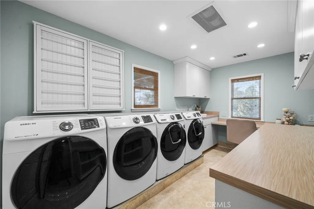 Oversized laundry room with dual sets and extra cabinetry and countertops.