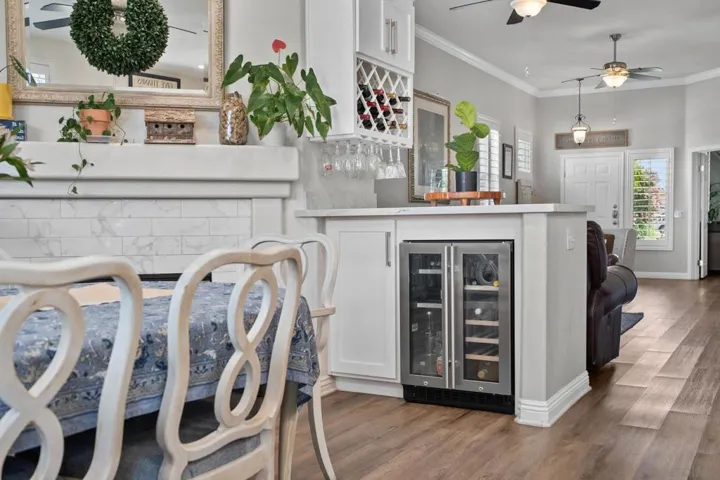 Custom wine and beverage bar includes a dual-zone refrigerator, integrated wine rack, and pull-out beverage storage.