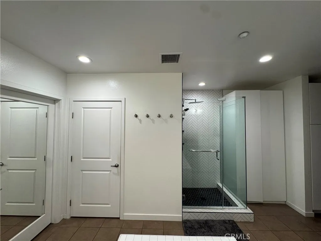 Toilet with a privacy door, and a large walk in closet with custom made closet organizer.