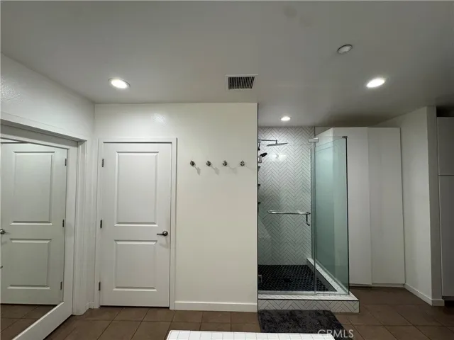 Toilet with a privacy door, and a large walk in closet with custom made closet organizer.