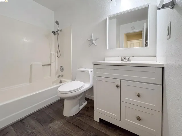 White vanity with integrated sink, chrome faucet, and framed mirror