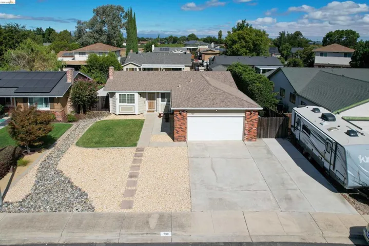 Single-story residence featuring a paved driveway, attached garage, and a combination of brick and siding exterior
