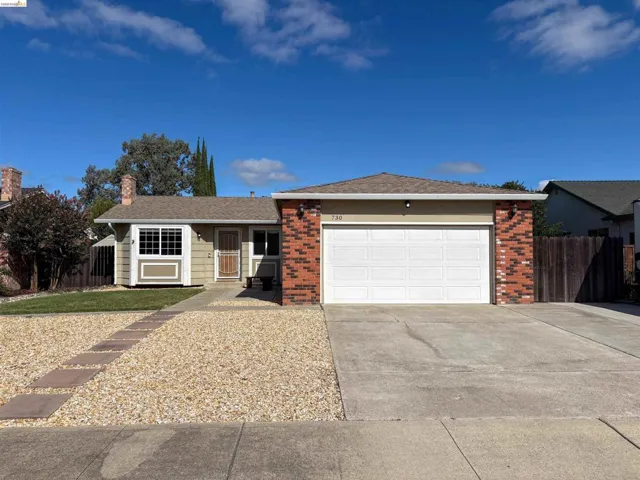 Single-story residence featuring a brick facade, attached two-car garage, and a front entry with a screen door