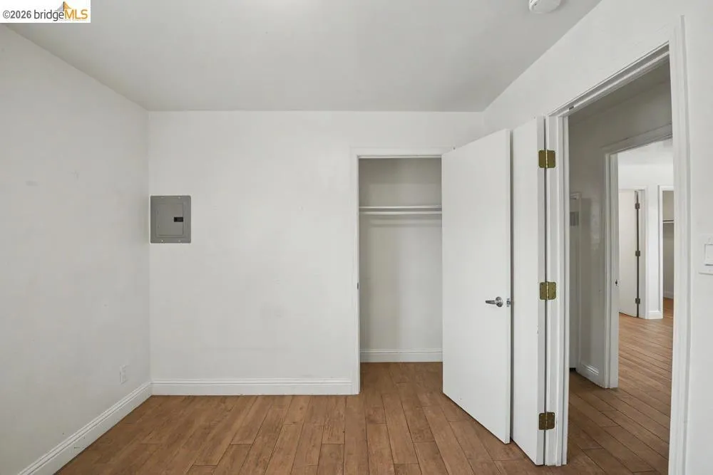 Wood-finish flooring throughout, bright white walls, and a recessed ceiling light