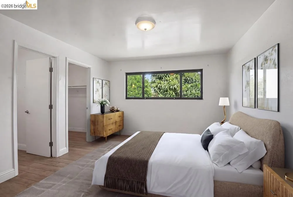 Hardwood-style flooring, a horizontal window with exterior greenery, and a ceiling-mounted light fixture