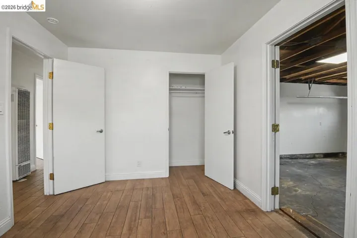 Wood-finish flooring, white walls, and a recessed ceiling light