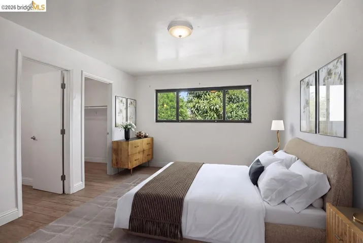 Hardwood-style flooring, a horizontal window with exterior greenery, and a ceiling-mounted light fixture