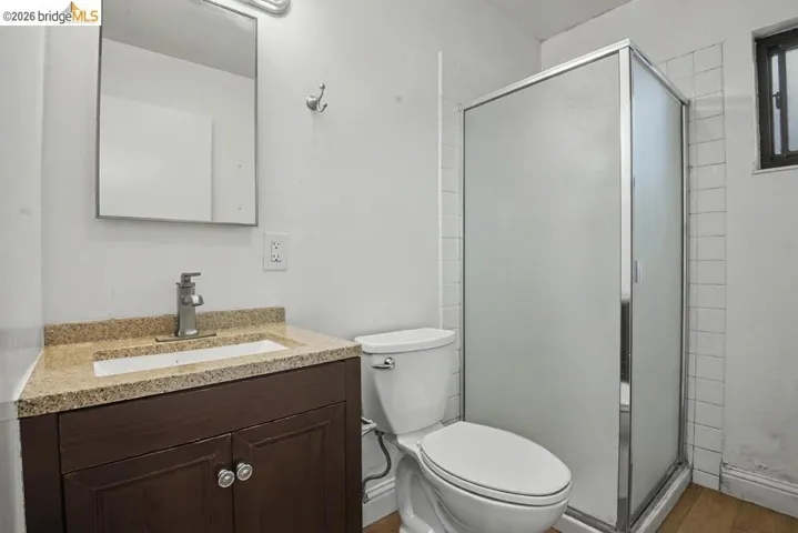Vanity with a granite-style countertop, undermount sink, and wood-finish cabinetry