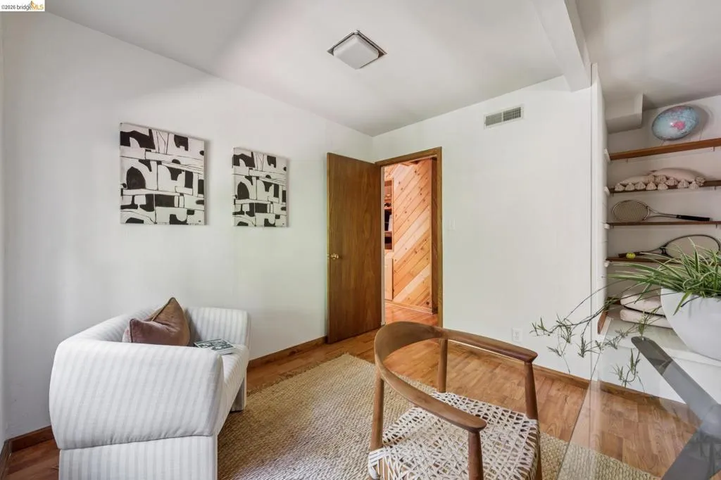 Wood-finish flooring with white walls and a ceiling-mounted light fixture