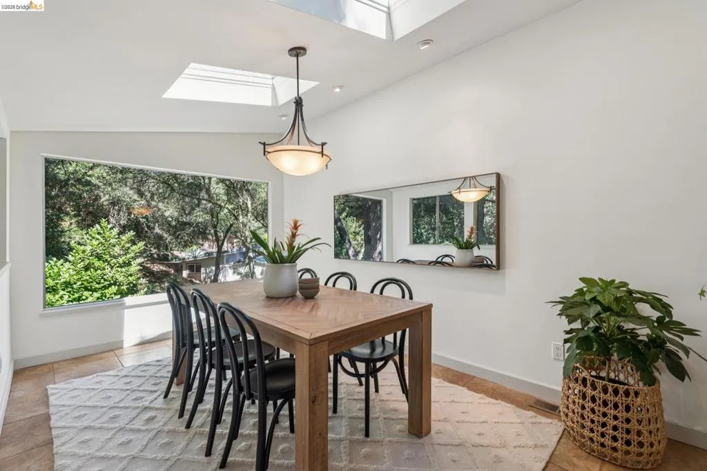 Vaulted ceiling with skylights, recessed lighting, and a contemporary chandelier