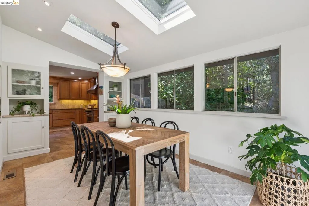 Vaulted ceiling with skylights, recessed lighting, and a decorative pendant light fixture