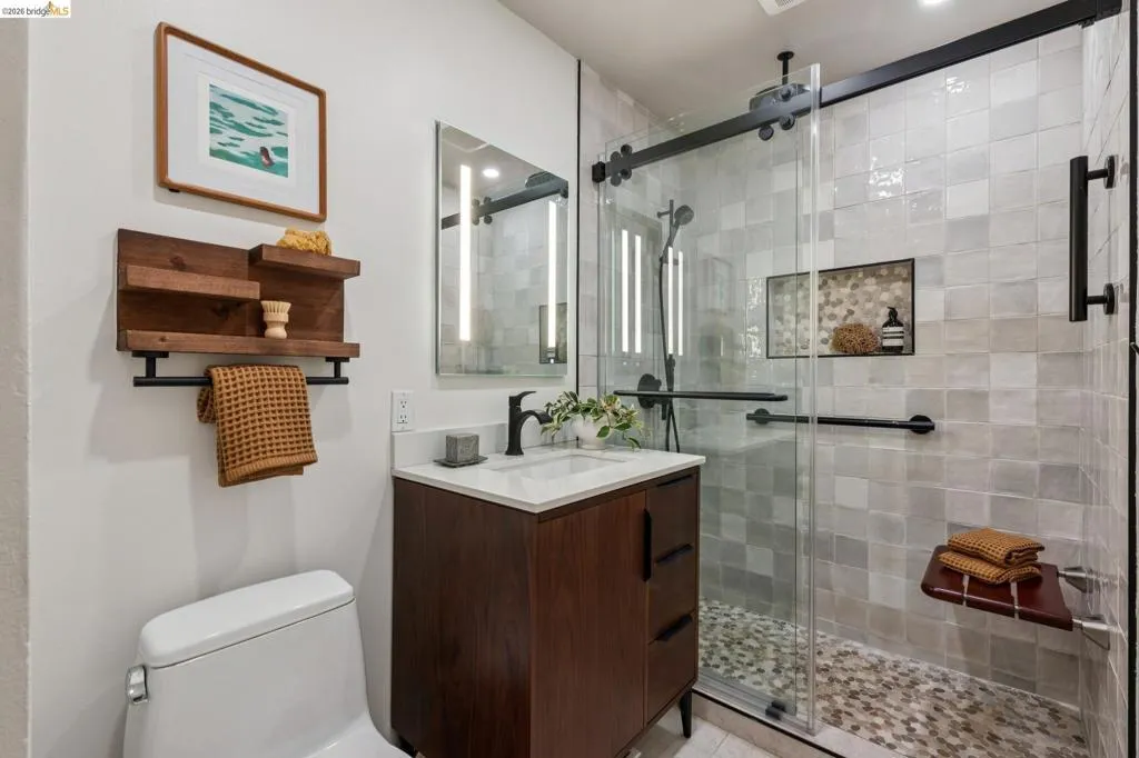 Modern vanity with white countertop, dark wood-finish cabinetry, and matte black faucet
