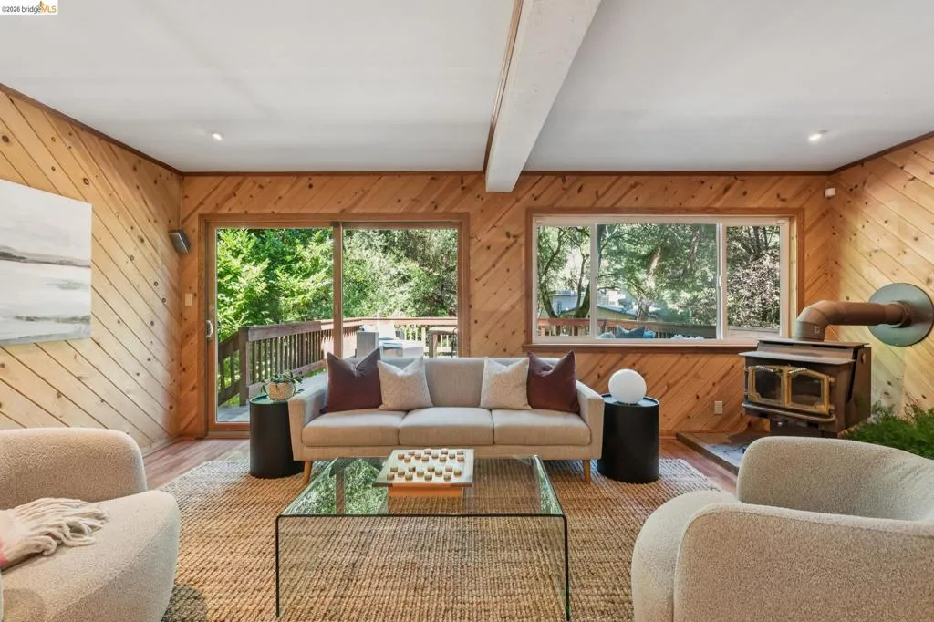 Wood-paneled interior walls, exposed ceiling beam, and wood-finish flooring