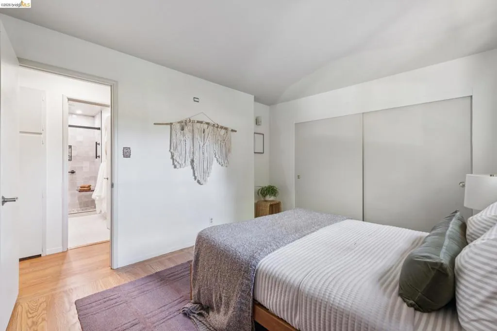 Wood-finish flooring with white walls and a vaulted ceiling