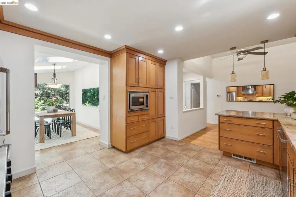 Kitchen featuring extensive wood cabinetry, recessed lighting, and tile flooring