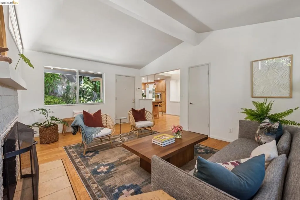 Vaulted ceiling, hardwood flooring, white brick fireplace, sliding window, and recessed lighting