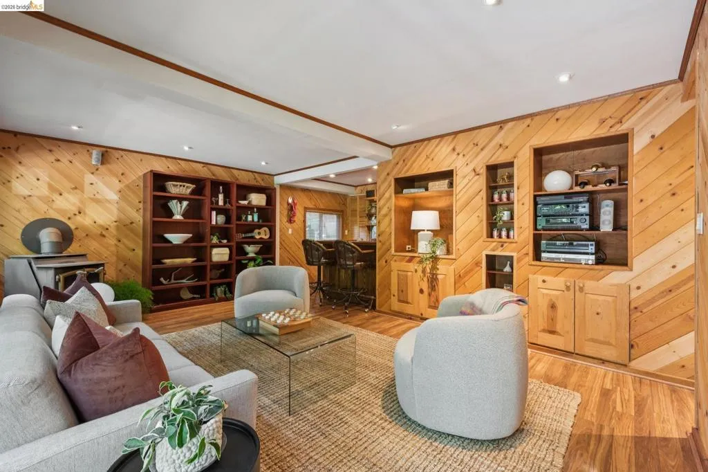 Wood-finish wall paneling, built-in shelving, recessed ceiling lighting, and wood-finish flooring