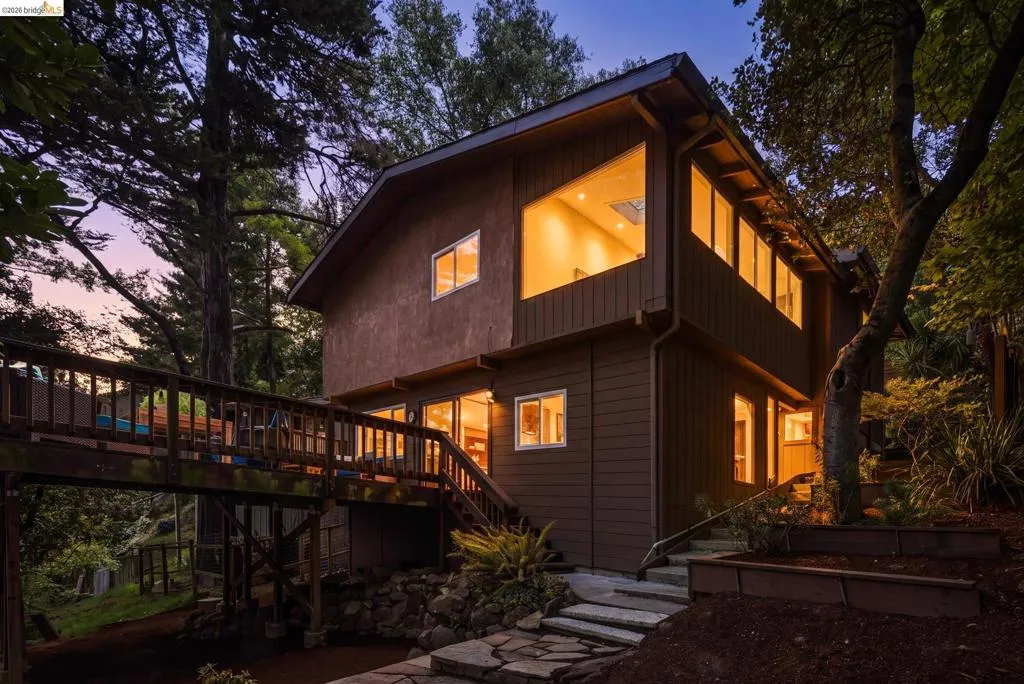 Multi-level exterior with rich brown siding and numerous windows