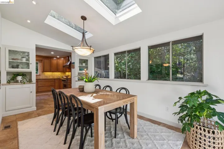 Vaulted ceiling with skylights, recessed lighting, and a decorative pendant light fixture