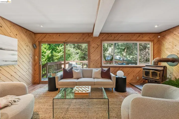Wood-paneled interior walls, exposed ceiling beam, and wood-finish flooring
