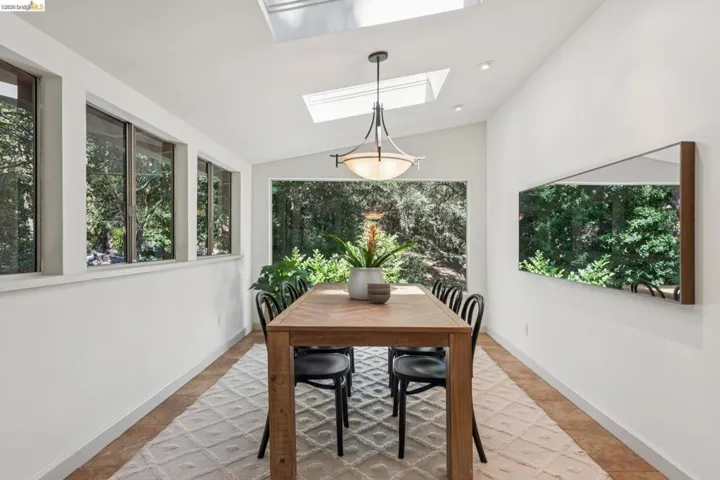 Vaulted ceiling with multiple skylights, recessed lighting, and a contemporary pendant fixture