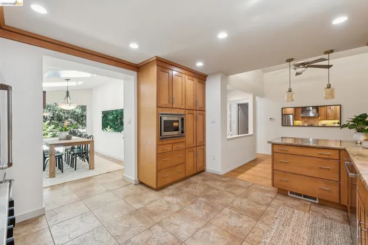 Kitchen featuring extensive wood cabinetry, recessed lighting, and tile flooring
