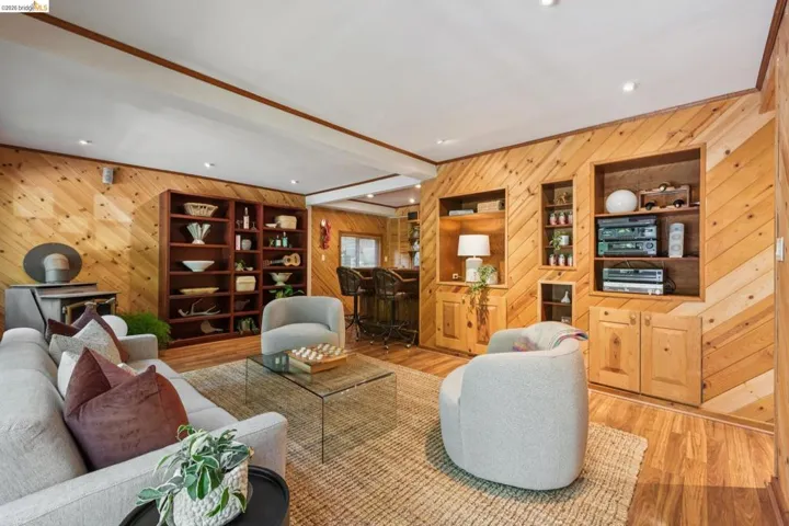 Wood-finish wall paneling, built-in shelving, recessed ceiling lighting, and wood-finish flooring