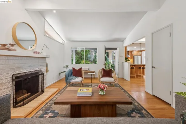 Living area with wood-finish flooring, a white brick fireplace, and recessed lighting