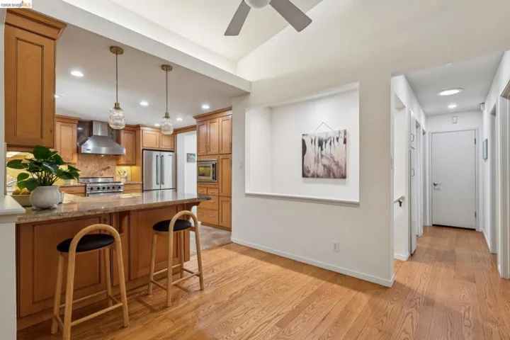 Hardwood flooring, wood cabinetry, granite countertop, stainless steel appliances, and recessed lighting