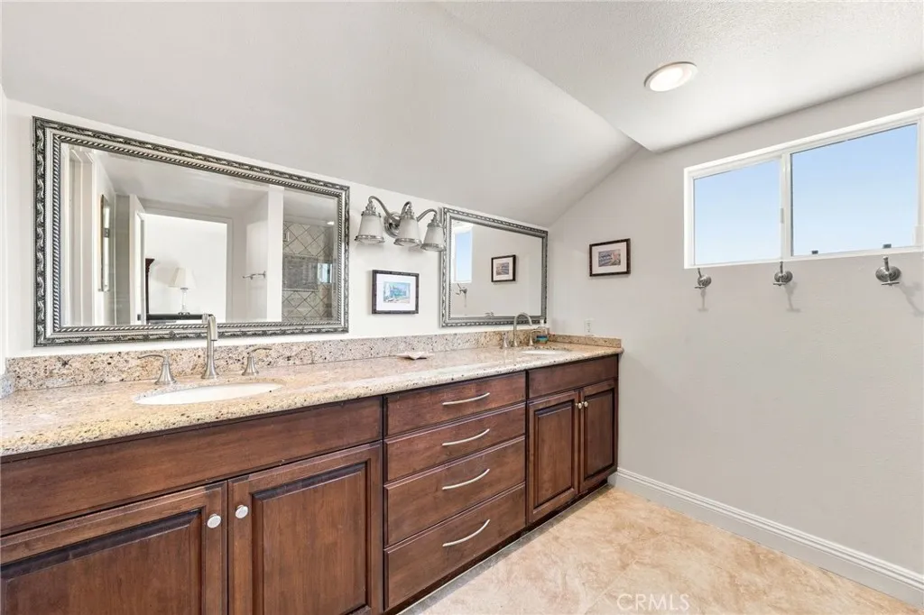 The upgraded primary bath features dual sinks, granite countertops, updated cabinetry, and a large custom finished walk-in shower with glass enclosure. The upgraded primary bath features dual sinks, granite countertops, updated cabinetry, and a large custom finished walk-in shower with glass enclosure.