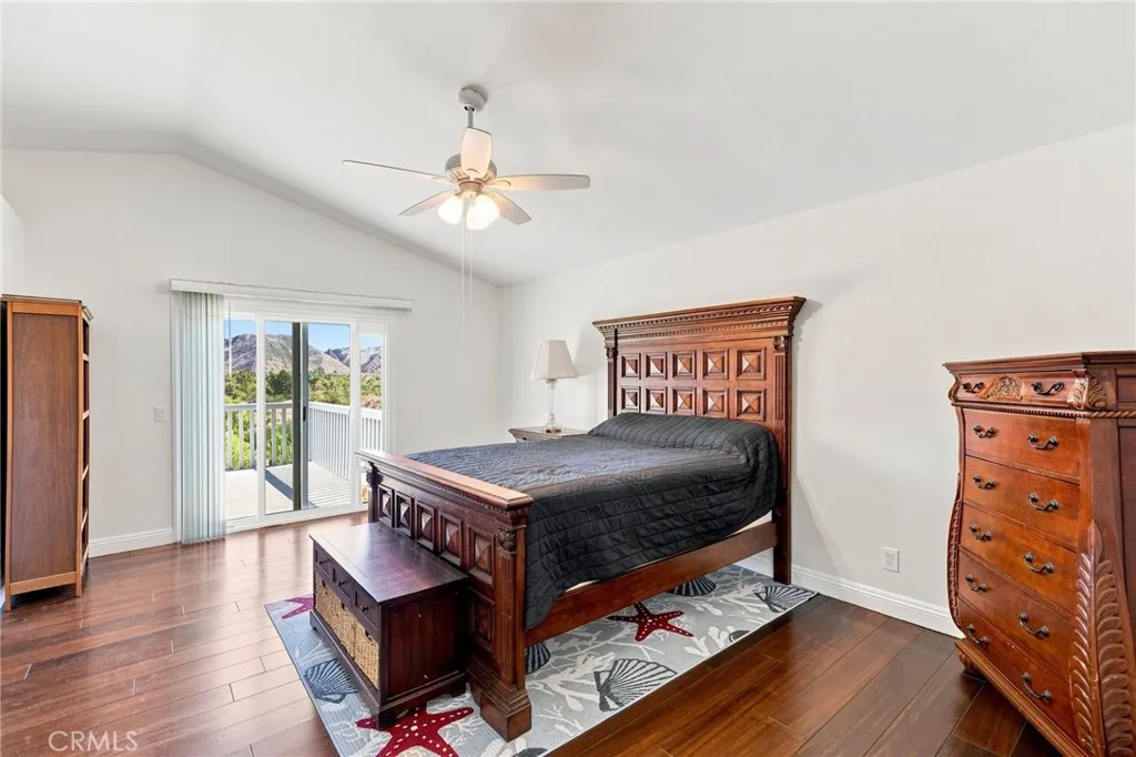 Upstairs, the spacious primary suite features volume ceilings, wood flooring, a walk-in closet, and direct access to a large private balcony deck Upstairs, the spacious primary suite features volume ceilings, wood flooring, a walk-in closet, and direct access to a large private balcony deck