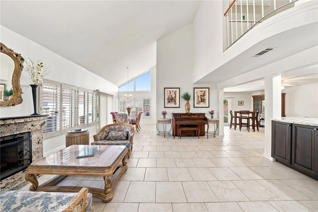 This space is highlighted with a fireplace, plantation shutters, and an abundance of natural light. This space is highlighted with a fireplace, plantation shutters, and an abundance of natural light.