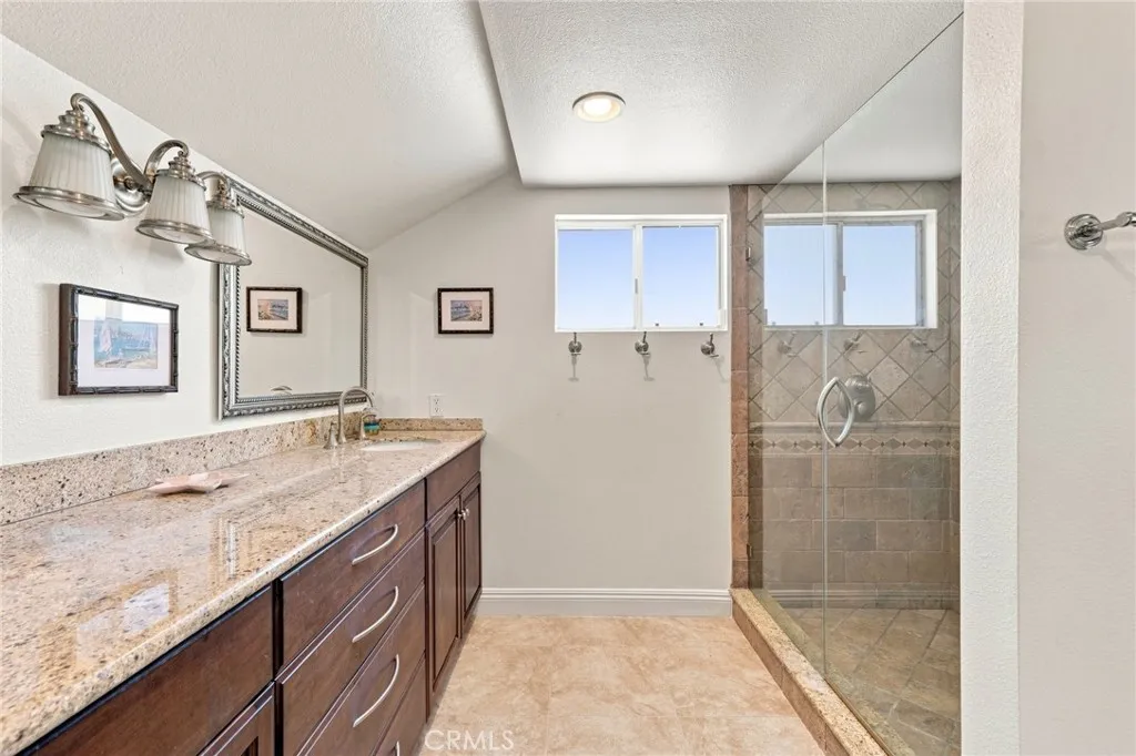 The upgraded primary bath features dual sinks, granite countertops, updated cabinetry, and a large custom finished walk-in shower with glass enclosure. The upgraded primary bath features dual sinks, granite countertops, updated cabinetry, and a large custom finished walk-in shower with glass enclosure.