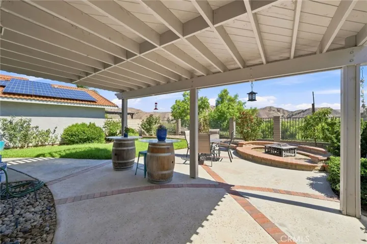 The backyard takes full advantage of the scenic setting with a covered patio, lawn area, fruit trees, fire pit, and plenty of space for outdoor dining, and entertaining