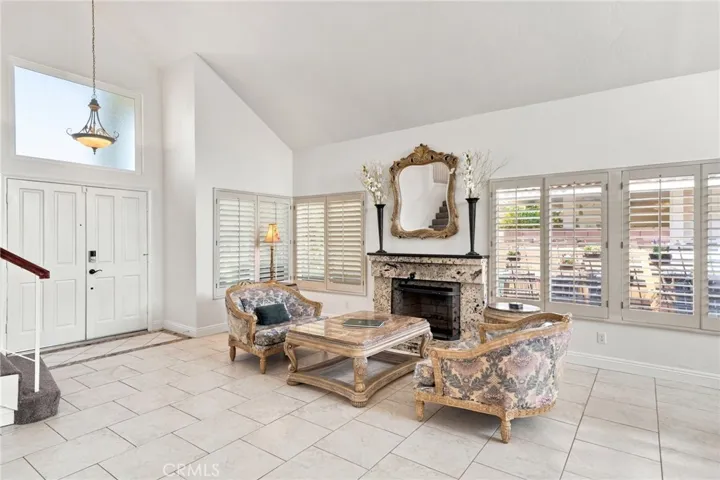 This space is highlighted with a fireplace, plantation shutters, and an abundance of natural light.