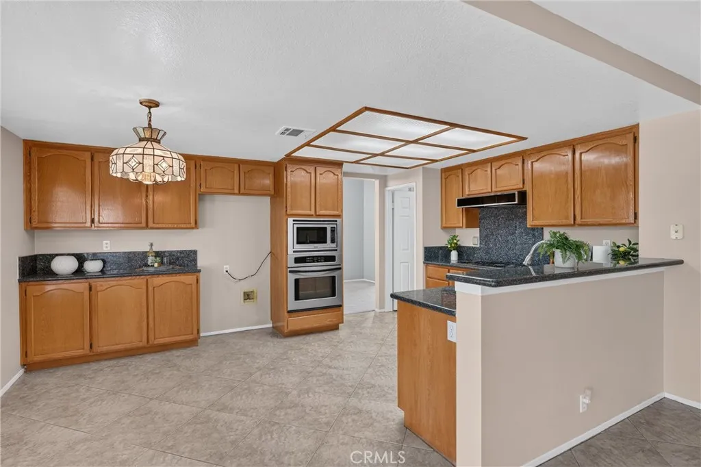 Spacious Kitchen: Granite Countertops, Double Oven, Gas Cooktop, Microwave and Dishwasher. Plenty of Cabinets