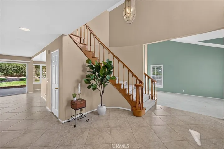 The formal entry offers plenty of space to welcome guests before flowing into the family room, where neutral tile creates a clean, cohesive look.