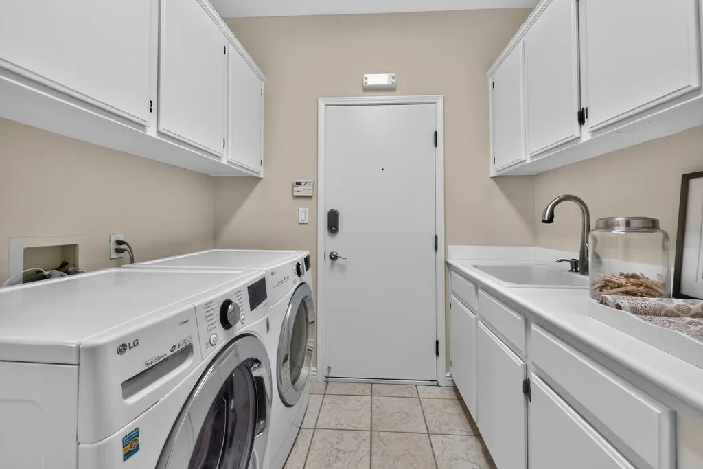 Laundry room with freshly painted cabinetry and sink leads to the 3 car garage
