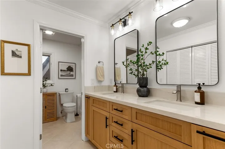 Master bathroom features a custom white oak vanity, quartz counter tops, framed mirrors and generous closets.