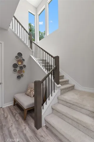 A striking architectural staircase is framed by expansive windows, filling the stairway with beautiful natural light.
