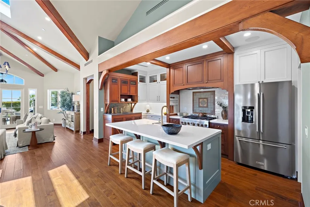 Custom kitchen features reclaimed Honduras mahogany cabinetry, quartz countertops, a farmhouse sink, high-end appliance package, and a handmade tile backsplash behind the range. Custom kitchen features reclaimed Honduras mahogany cabinetry, quartz countertops, a farmhouse sink, high-end appliance package, and a handmade tile backsplash behind the range.