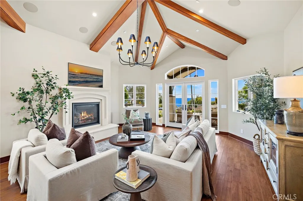 Living room with soaring ceilings and distressed maple hardwood flooring that extends throughout the home, complemented by a gas fireplace with a Veristone surround. Living room with soaring ceilings and distressed maple hardwood flooring that extends throughout the home, complemented by a gas fireplace with a Veristone surround.