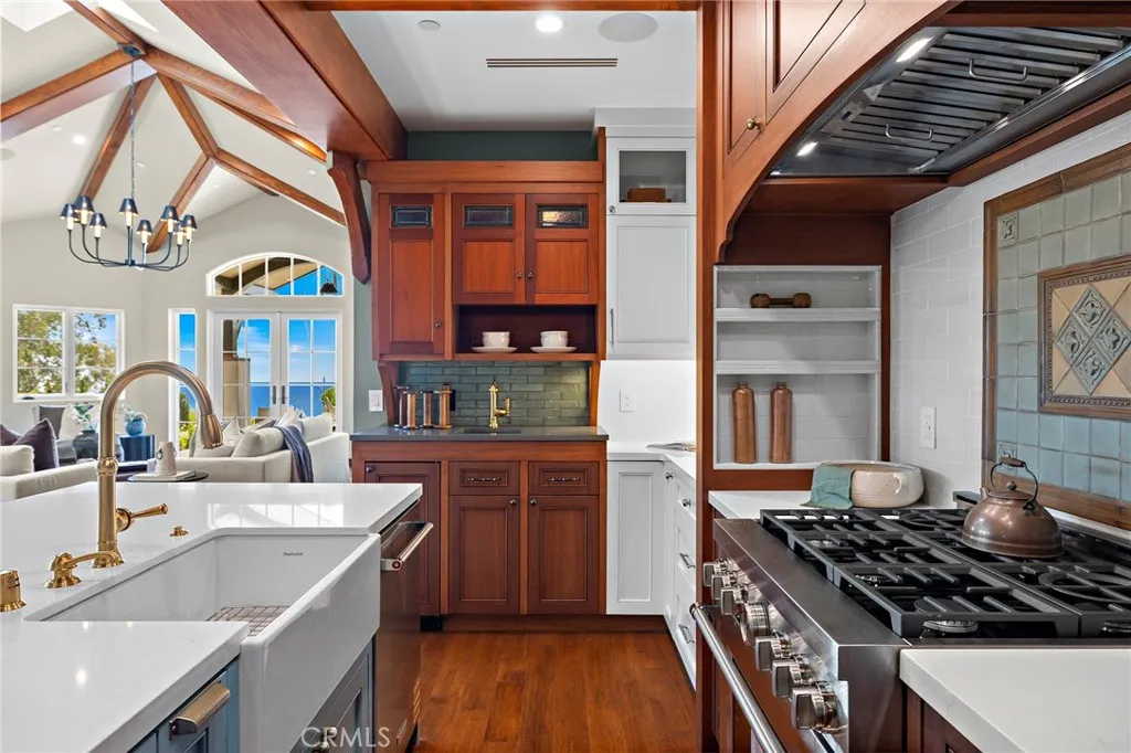 A dedicated bar with custom cabinetry, quartz counters, and a Soft Tetris tile backsplash creates a natural setting for entertaining. A dedicated bar with custom cabinetry, quartz counters, and a Soft Tetris tile backsplash creates a natural setting for entertaining.