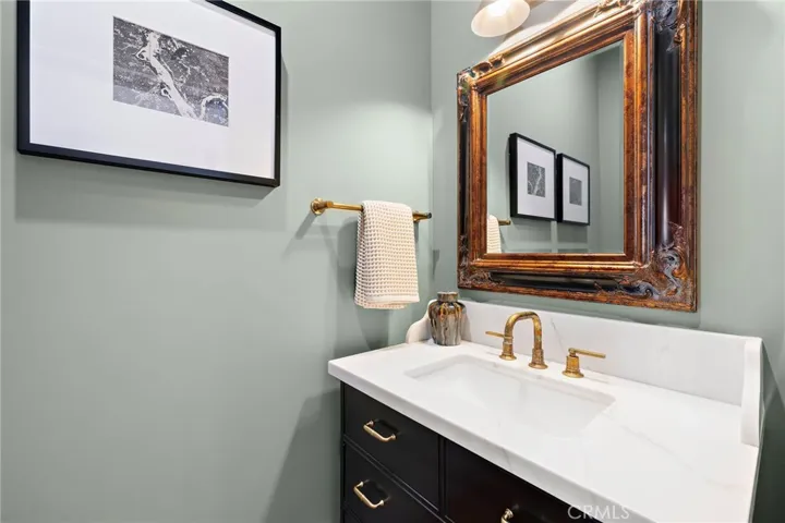 Powder bath located off the living area complete with Toto toilet, Phylrich French Brass faucet and reclaimed Honduras Mahogany mirrored pocket door