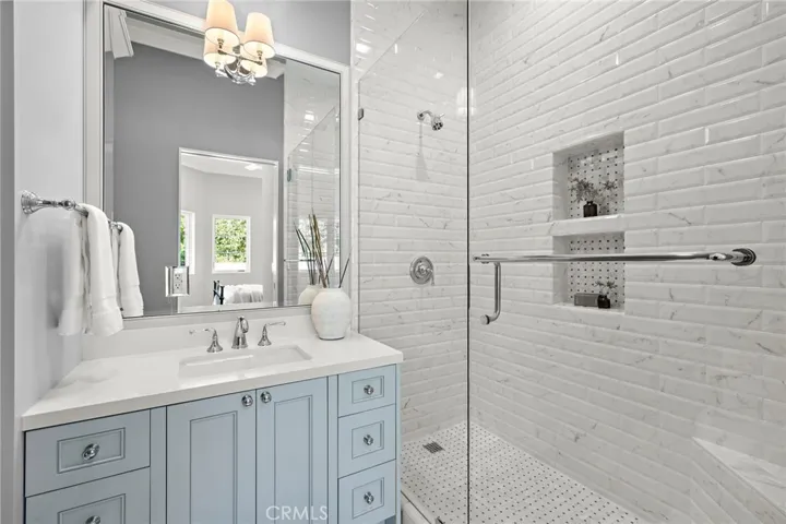 En-suite bath to guest bedroom one with Toto toilet, Phylrich faucets, and white Quartz countertops. Shower features Carrera basketweave and Ceramica Carrera.