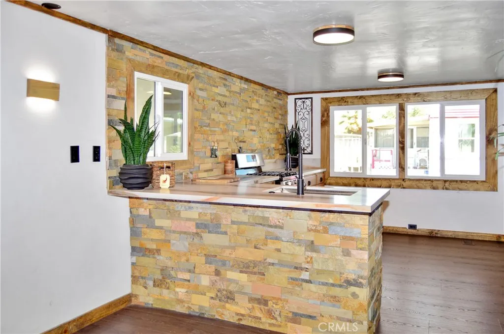 Big, Beautiful Kitchen with New Cabinetry, Quartz Countertops, Stainless Steel Sink with Sprayer, Stainless Steel and Black Range, Wood and Stone Accents, Custom Lighting, Black Hardware, and a Wood-Trimmed Refrigerator Big, Beautiful Kitchen with New Cabinetry, Quartz Countertops, Stainless Steel Sink with Sprayer, Stainless Steel and Black Range, Wood and Stone Accents, Custom Lighting, Black Hardware, and a Wood-Trimmed Refrigerator