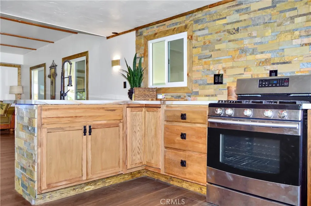 Big, Beautiful Kitchen with New Cabinetry, Quartz Countertops, Stainless Steel Sink with Sprayer, Stainless Steel and Black Range, Wood and Stone Accents, Custom Lighting, Black Hardware, and a Wood-Trimmed Refrigerator Big, Beautiful Kitchen with New Cabinetry, Quartz Countertops, Stainless Steel Sink with Sprayer, Stainless Steel and Black Range, Wood and Stone Accents, Custom Lighting, Black Hardware, and a Wood-Trimmed Refrigerator