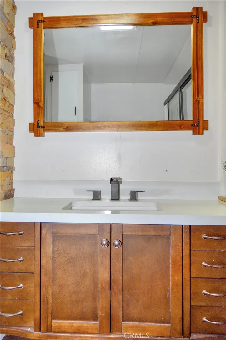 Remodeled Bath with Glass-Enclosed Shower Stall, Furniture-Style Vanity with Stylish Square Sink, Framed Mirror, Open Shelving, Modern Black Fixtures, and a Bidet Remodeled Bath with Glass-Enclosed Shower Stall, Furniture-Style Vanity with Stylish Square Sink, Framed Mirror, Open Shelving, Modern Black Fixtures, and a Bidet